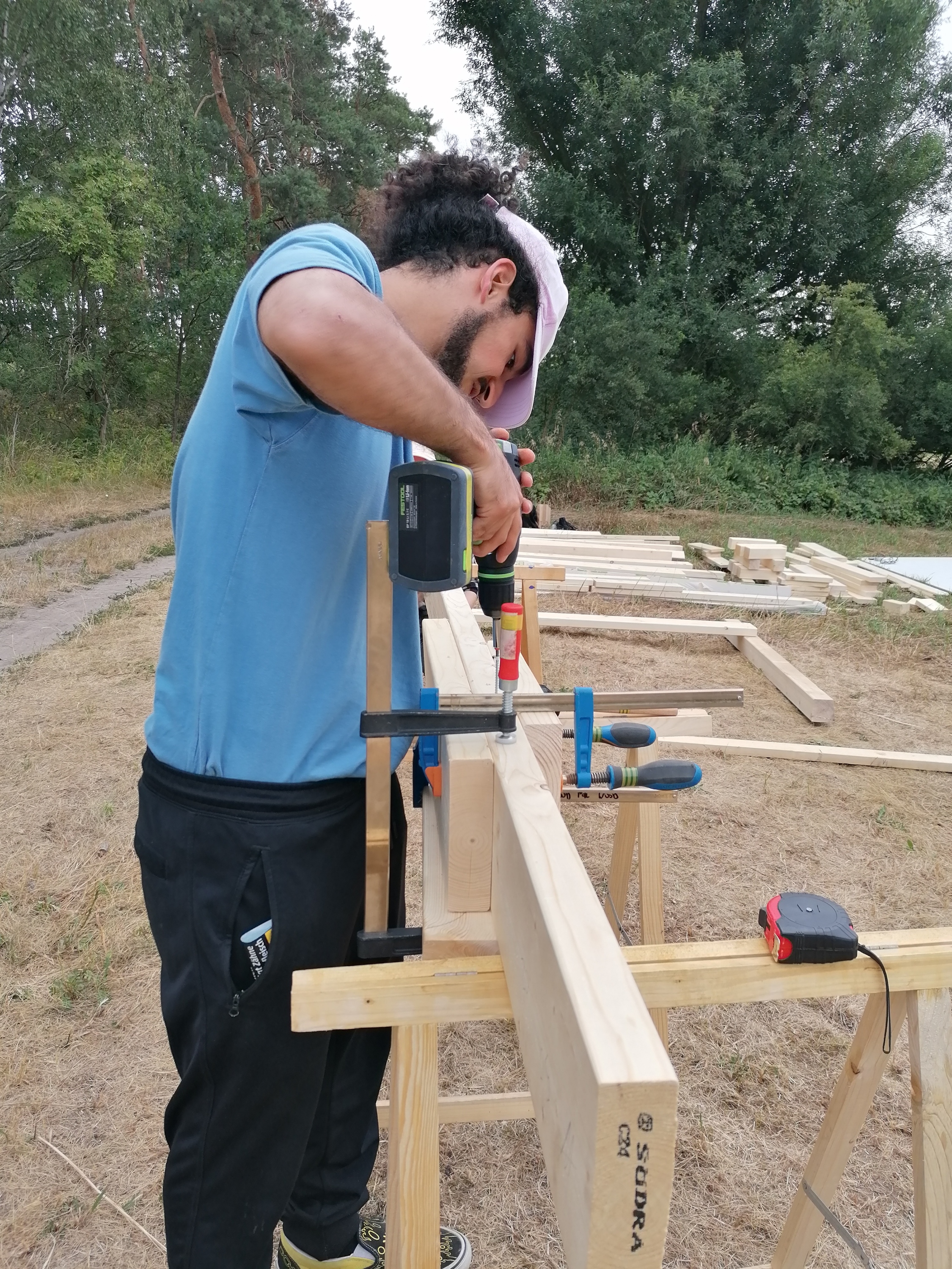 Zdjęcie przedstawia jednego ze studentów pracującego przy tworzeniu drewnianej instalacji. Fot. Archiwum RDLP w Poznaniu