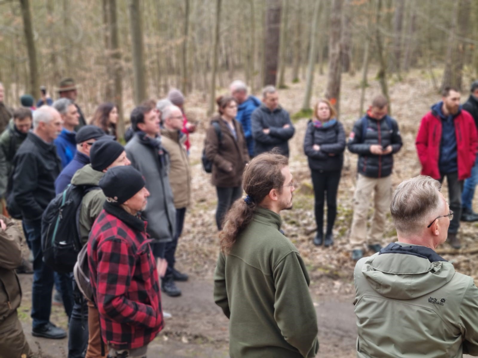 Zdjęcie przedstawia grupę ludzi w lesie, słuchających wypowiedzi. Fot. K. Kapałka