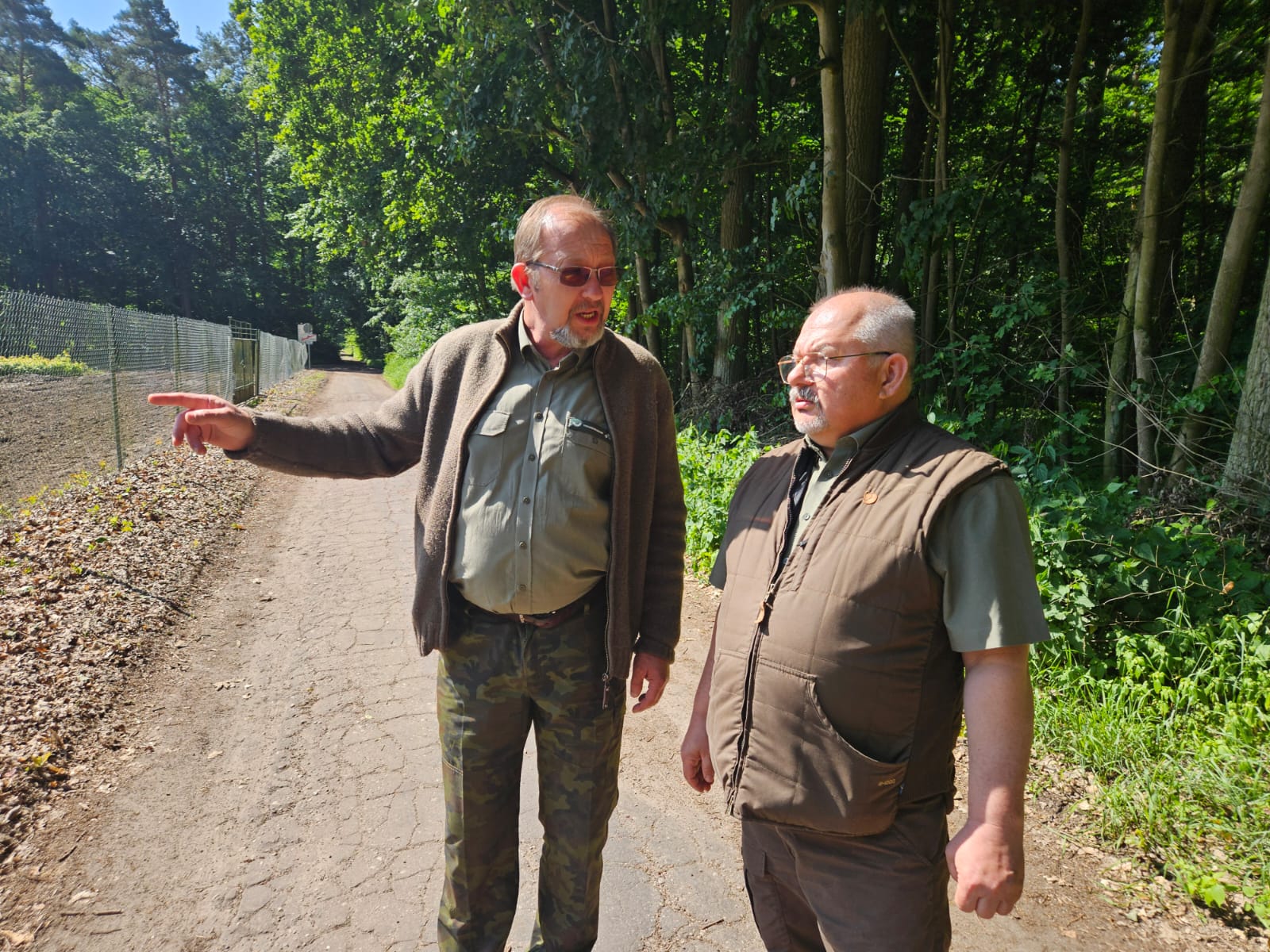 Zdjęcie przedstawia dwóch leśników stojących przy płocie okalających szkółkę leśną. Fot. I. Niemiec