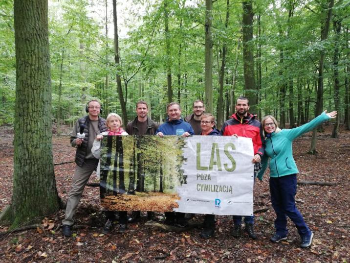 Zdjęcie&#x20;przedstawia&#x20;wszystkich&#x20;laureatów&#x20;konkursu&#x20;oraz&#x20;leśników&#x20;z&#x20;banerem&#x20;pt&#x2e;&#x20;&#x22;Las&#x20;poza&#x20;cywilizacją&#x22;&#x20;w&#x20;lesie&#x20;Nadleśnictwa&#x20;Taczanów&#x2e;&#x20;Fot&#x2e;&#x20;Tomasz&#x20;Maćkowiak&#x20;&#x28;RDLP&#x20;w&#x20;Poznaniu&#x29;&#x2e;